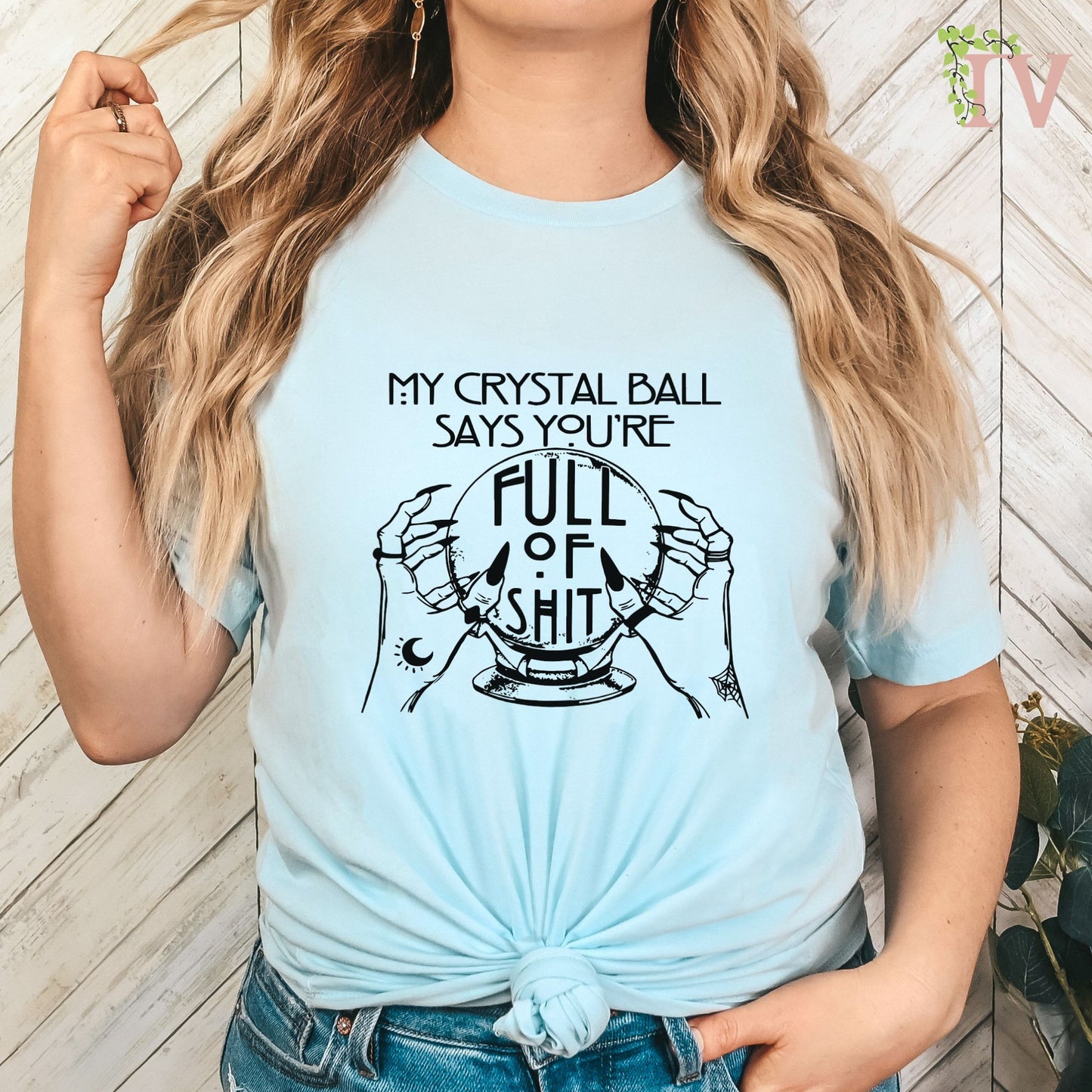 This is a black plastisol ink screen print transfer, depicting an American Horror Story Vibe, with a similiar font! The image is two hands holding a crystal ball with the quote "My crystal ball says your are full of shit" at the top and center.